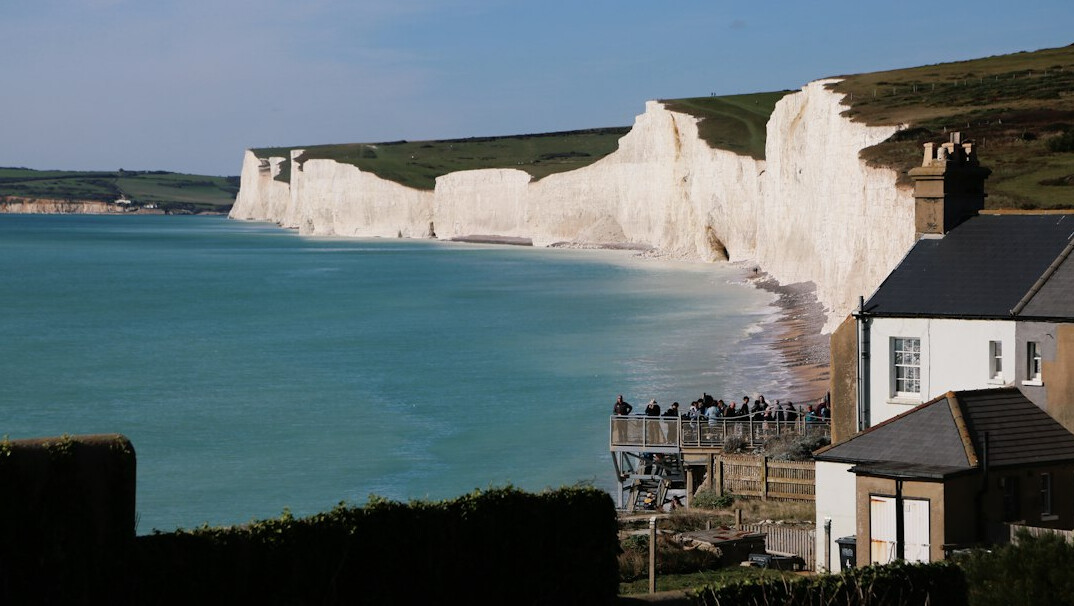 Tall white chalk cliffs meeting the sea