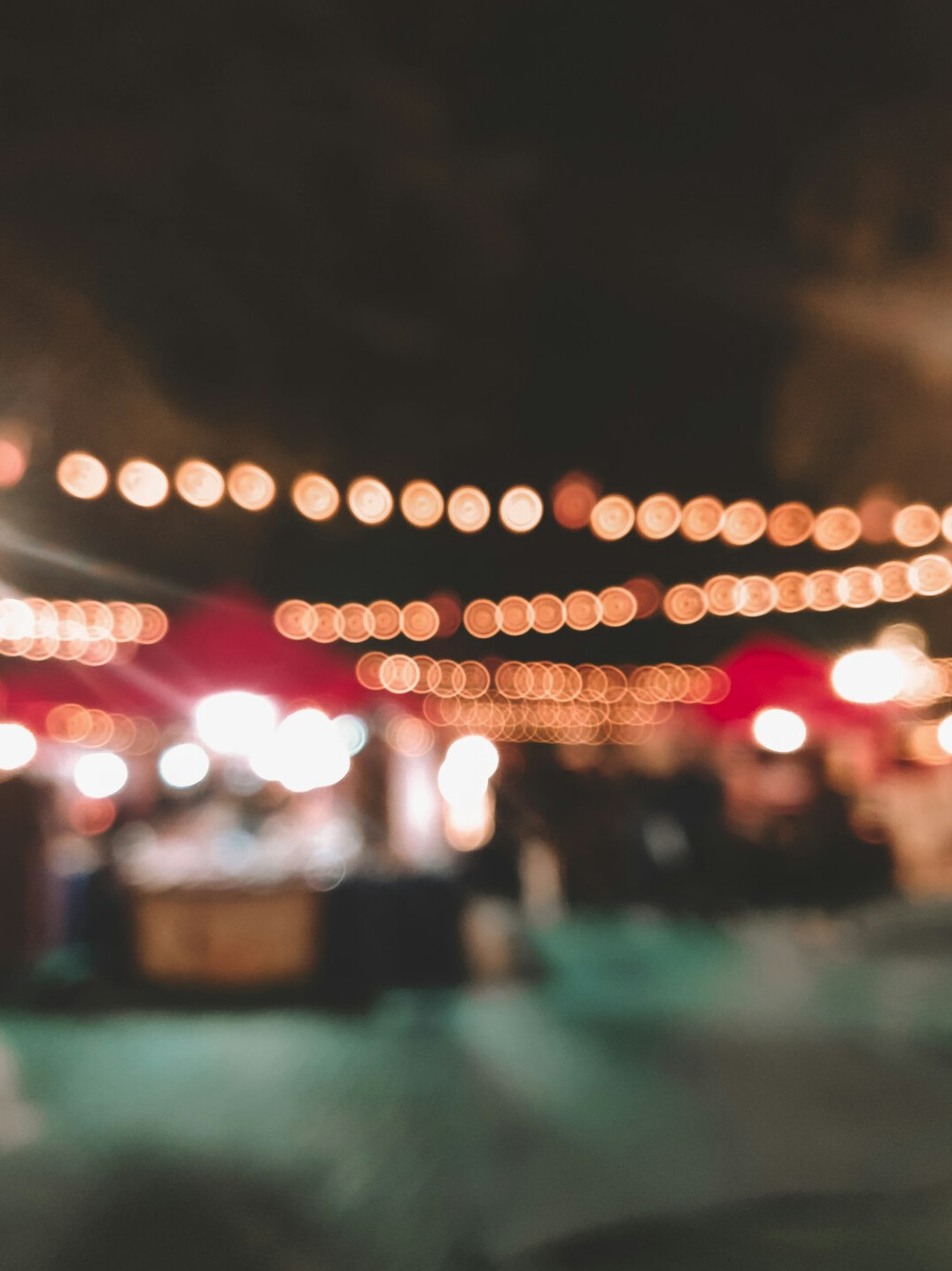 Illuminated stalls at an outdoor Christmas market at night
